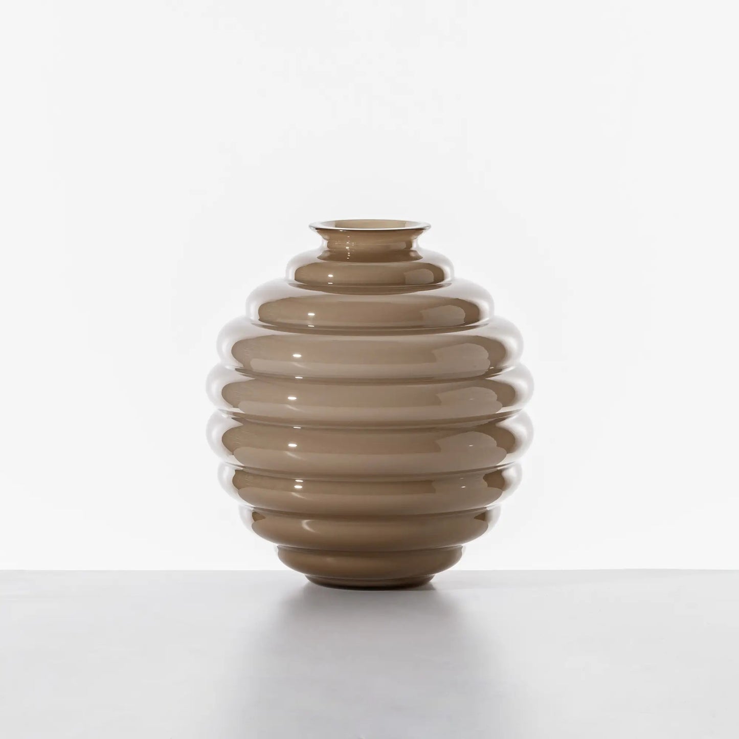 Venini Deco Vase | A Murano glass vase defined by rhythmic, flowing rings that expand and contract in a graceful, dance-like motion | Originally designed by Napoleone Martinuzzi in 1930, the Deco vase embodies timeless elegance and sculptural harmony | The repeated circular forms create a play of ripples and reflections, capturing the essence of movement | A celebrated icon of Venetian glass artistry | Design by Venini | Tableware & decorative objects | 2Jour Concierge, your luxury lifestyle shop.