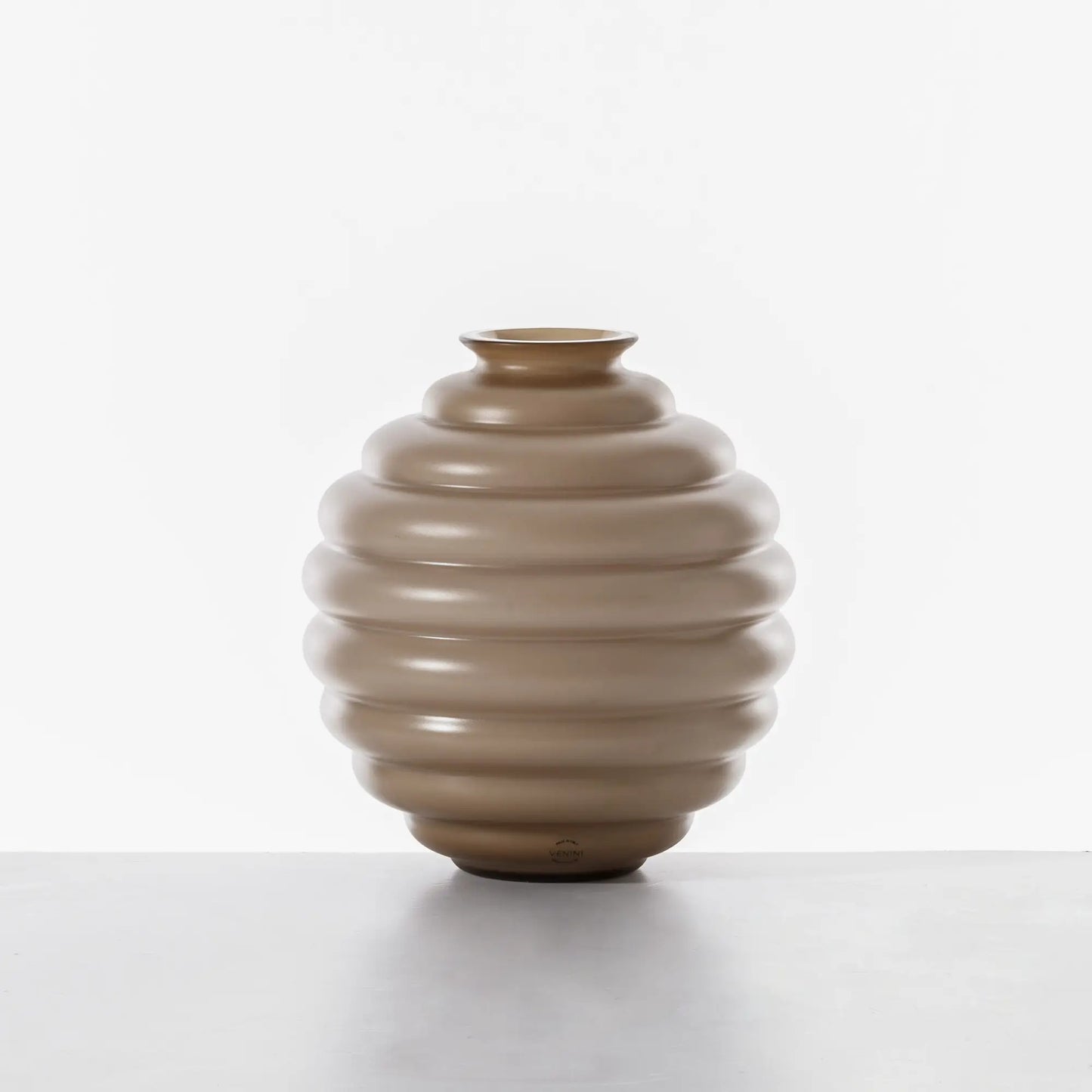 Venini Deco Vase | A Murano glass vase defined by rhythmic, flowing rings that expand and contract in a graceful, dance-like motion | Originally designed by Napoleone Martinuzzi in 1930, the Deco vase embodies timeless elegance and sculptural harmony | The repeated circular forms create a play of ripples and reflections, capturing the essence of movement | A celebrated icon of Venetian glass artistry | Design by Venini | Tableware & decorative objects | 2Jour Concierge, your luxury lifestyle shop.