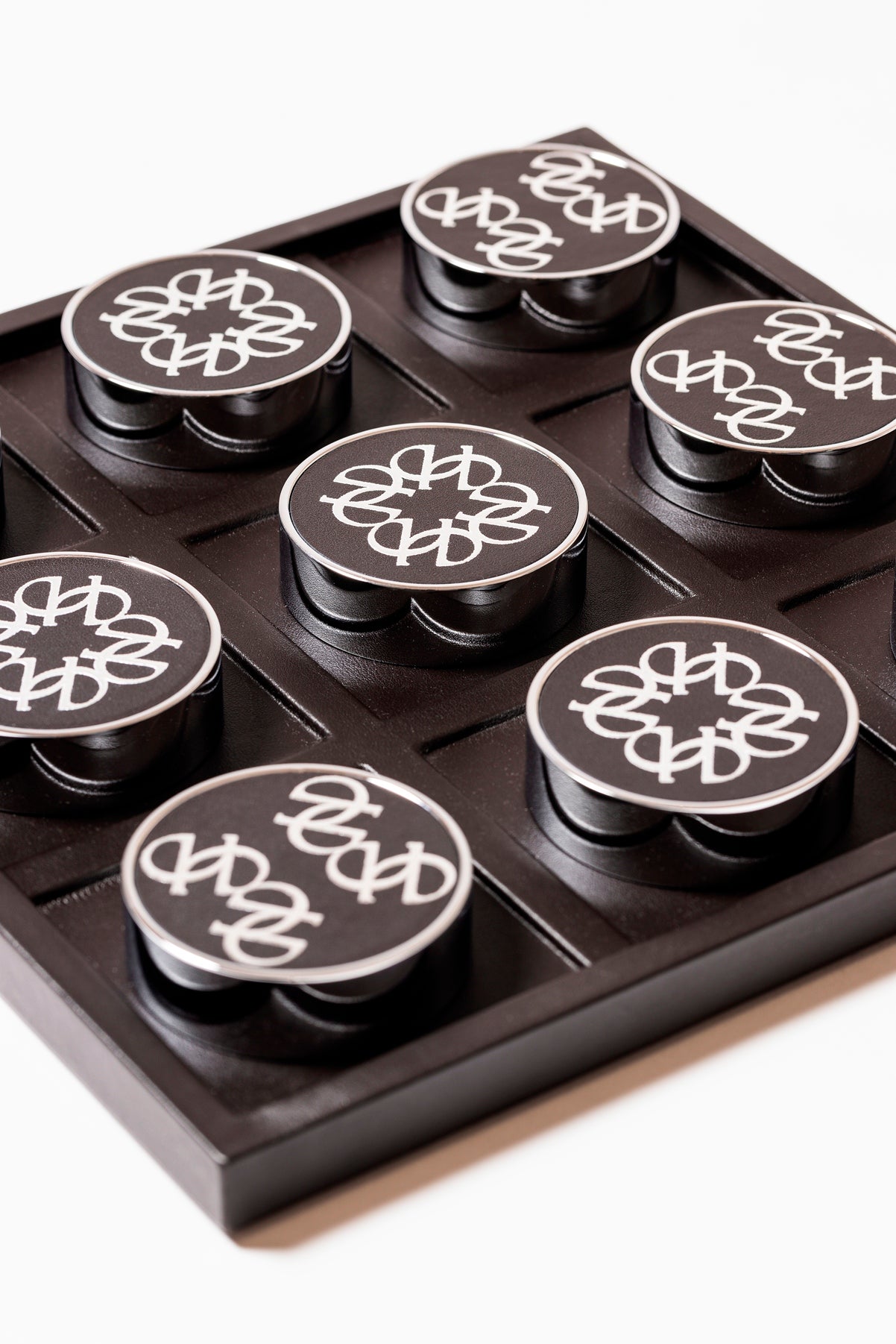 Giobagnara x Elie Saab Ecusson Tic Tac Toe | Leather tray with dividers featuring the Elie Saab Monogram pattern | Includes polished palladium playing pieces with leather inserts and shiny silver debossed decorations | Games and Entertainment | 2Jour Concierge, your luxury lifestyle shop