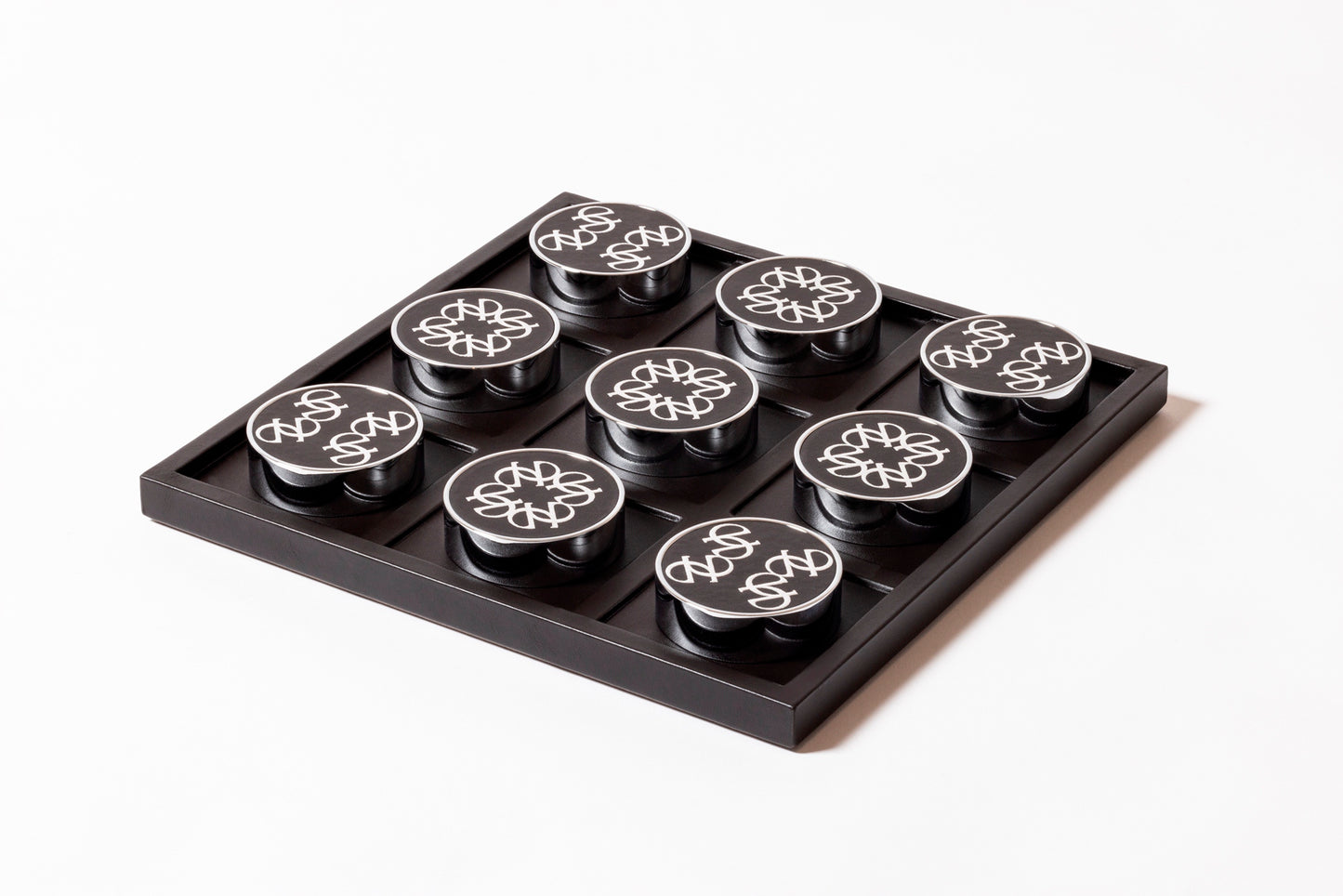 Giobagnara x Elie Saab Ecusson Tic Tac Toe | Leather tray with dividers featuring the Elie Saab Monogram pattern | Includes polished palladium playing pieces with leather inserts and shiny silver debossed decorations | Games and Entertainment | 2Jour Concierge, your luxury lifestyle shop