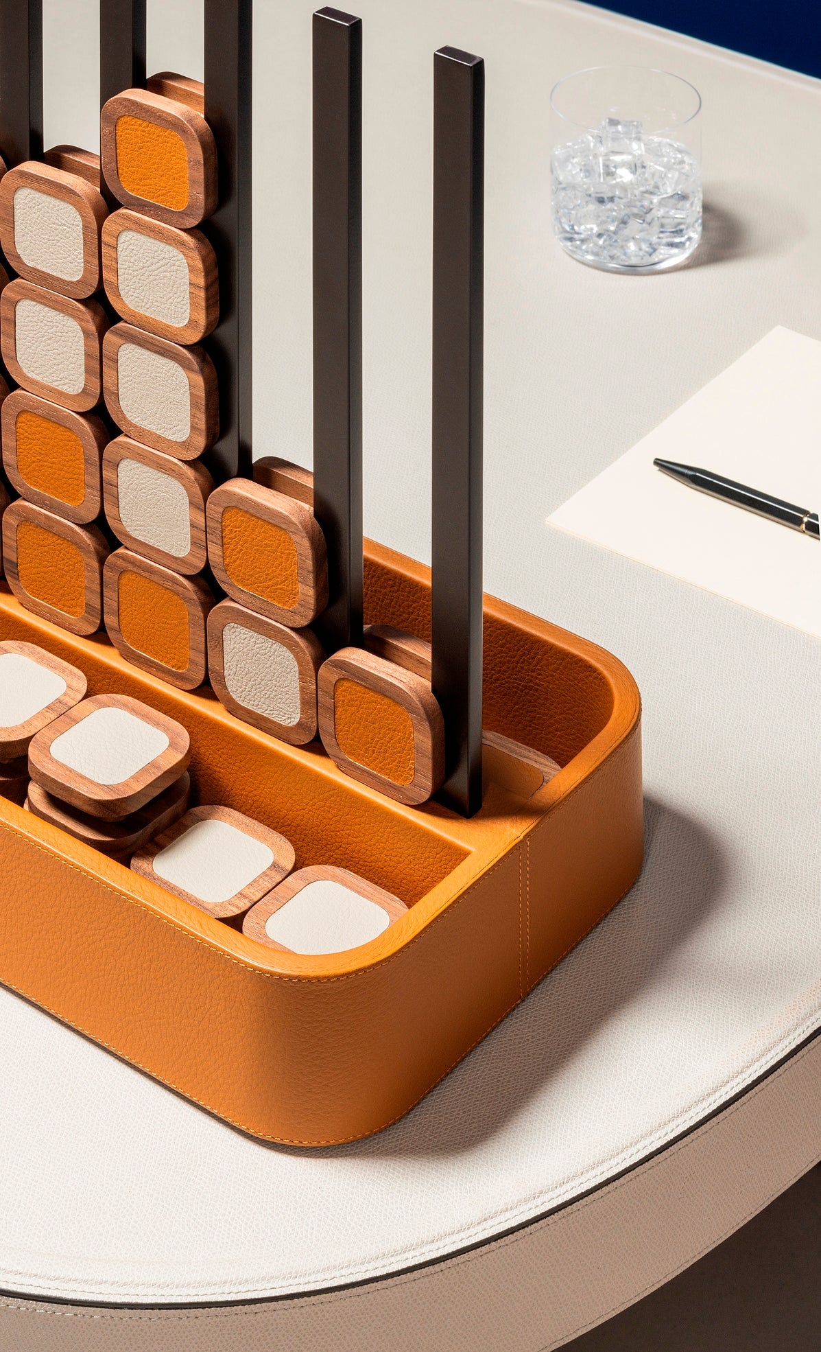 Giobagnara x Poltrona Frau connect 4 | Leather-covered base with walnut wood playing pieces featuring fine leather inserts | Accented with burnished brushed bronze details | A stylish, elevated take on a timeless game | Entirely made in Pelle Frau® | Home decor & game sets | 2Jour Concierge, your luxury lifestyle shop