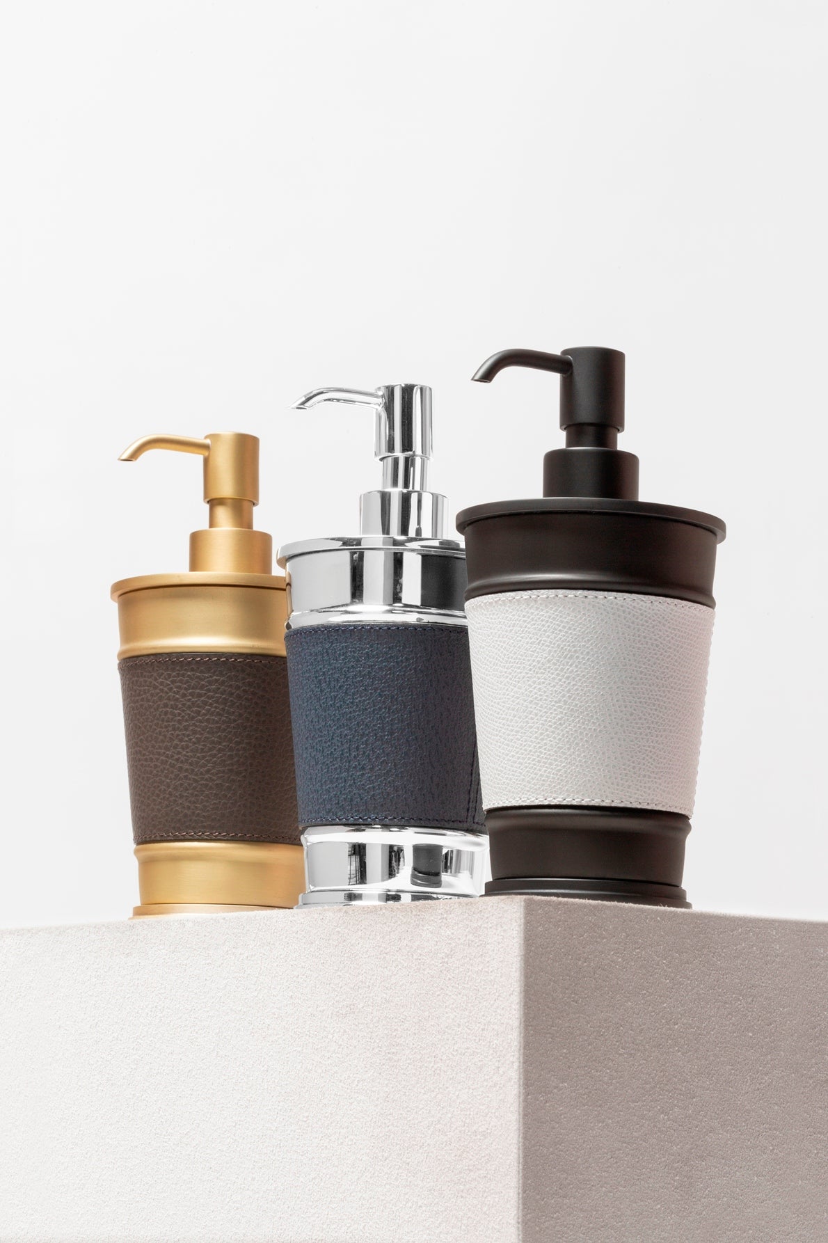 Giobagnara Manhattan soap dispenser | Part of the Manhattan bathroom collection | Features an inverted truncated cone metal structure with fine leather inserts | Decorative indentations create a modern architectural look | Non-slip waterproof rubber base | Available in chrome, bronze, or brass finishes | Bathroom accessories | 2Jour Concierge, your luxury lifestyle shop