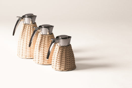 Vincennes Carafe by Pigment France | Partially rattan-covered insulated stainless steel carafe with chrome-plated finish. Two-chamber structure maintains liquid temperatures. Precise pouring with specially developed hinged lid for one-hand operation. | Tableware and Drinkware | 2Jour Concierge, your luxury lifestyle shop