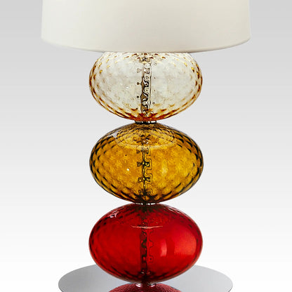 Abat-Jour Lamp by Venini | Stem features spheres capturing light reflections with surface texture from the ancient "balloton" technique | Table lamp adorned with one to three blown glass "balloton" elements in various colors | Base available in chrome-plated or black nickel metal | White fabric lampshade | Home Decor Lighting | 2Jour Concierge, your luxury lifestyle shop