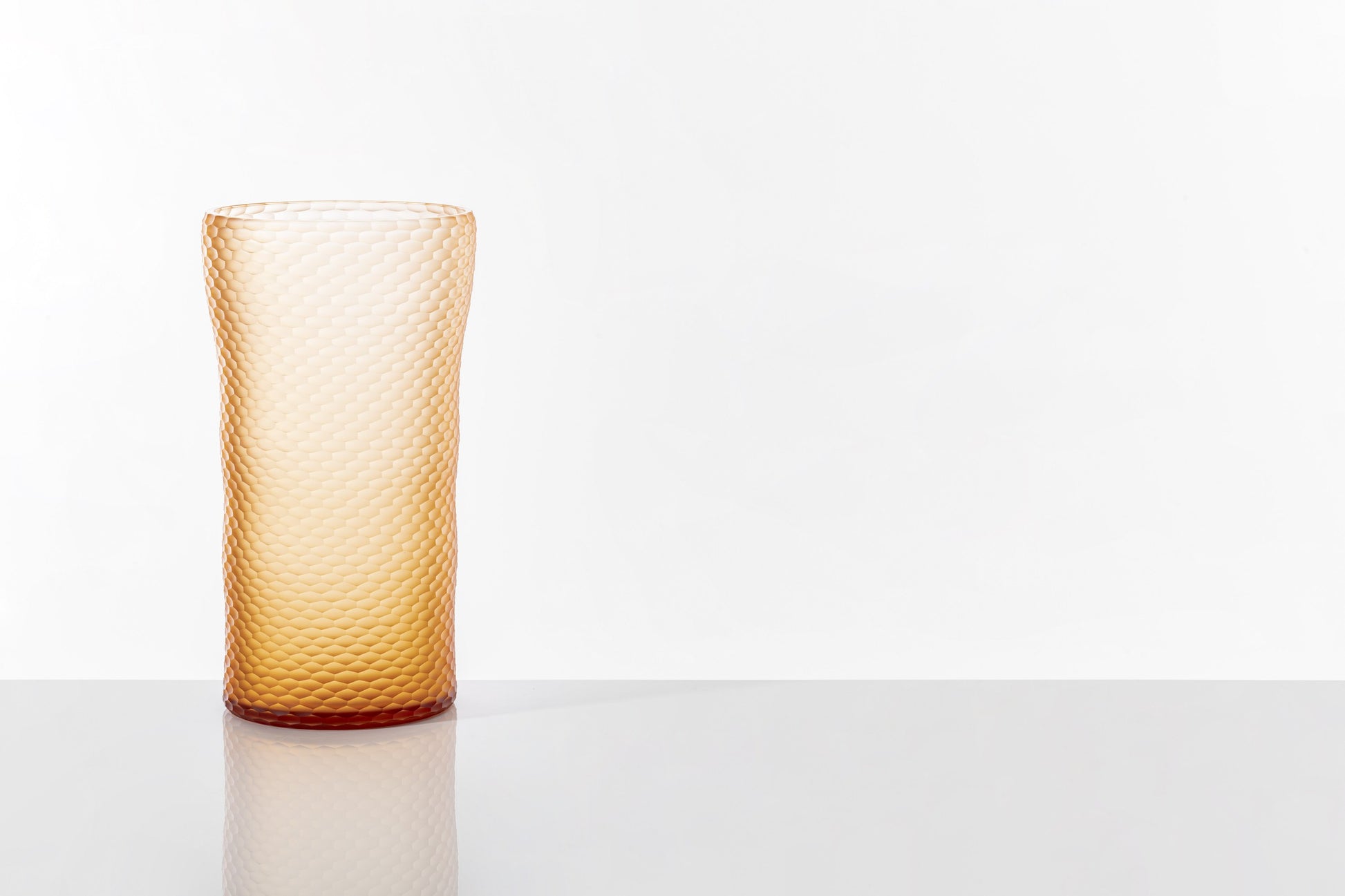 Battuto A Nido D’ape Vase by Venini | Not linear but wavy, featuring a textured surface with small hexagons resembling a honeycomb or ancient handmade textiles | Inspired by nature, designed by Carlo Scarpa, sculpted by master glass grinders | Made of Murano glass in the brand-new Peach variant | Color: Pesca | Designer: Carlo Scarpa | Collection: Pesca | Limited edition of 99 pieces | Home Decor Vases | 2Jour Concierge, your luxury lifestyle shop