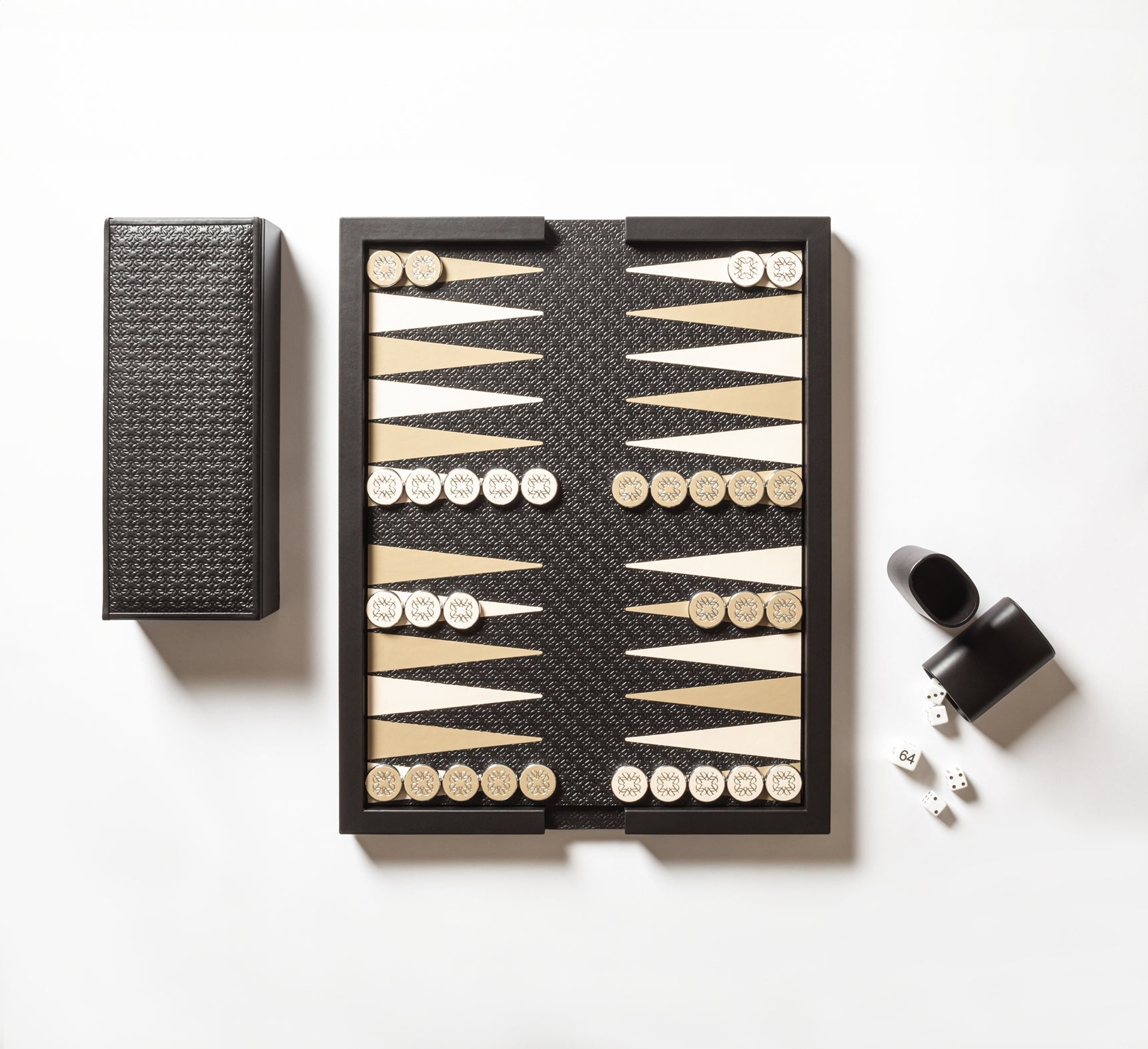 Giobagnara x Elie Saab Monogram Backgammon | Leather-covered tray with reversible leather pad: inlaid backgammon playing field on one side, sleek monochrome surface with Elie Saab Monogram pattern on the other | Includes a leather-covered wood box with coordinated leather cover | Contains playing accessories: polished palladium backgammon checkers with leather inserts and silver debossed decorations, 2 leather dice cups, 4 dice, and a doubling cube | Luxurious and elegant game set | Home Decor and Games