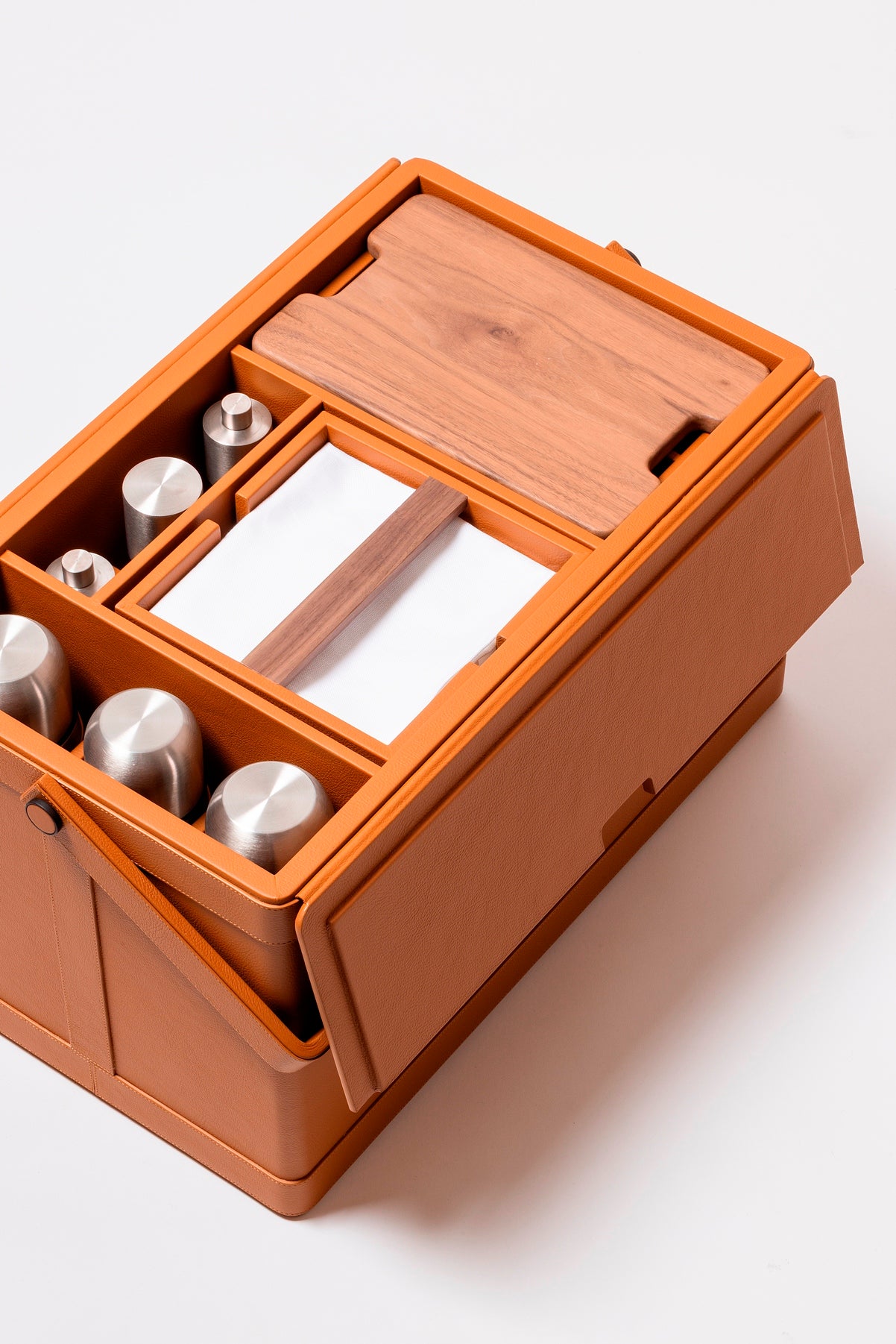 Giobagnara x Poltrona Frau picnic trunk | Leather-covered structure with tilting solid handle, designed for portability and elegance | Fully equipped with a complete picnic set including borosilicate glasses, thermoses, food containers, porcelain plates and cups, cutlery, and more | Walnut chopping board, fine cotton accessories, and leather-covered grinders included | Entirely made in Pelle Frau® | Home accessories & travel essentials | 2Jour Concierge, your luxury lifestyle shop