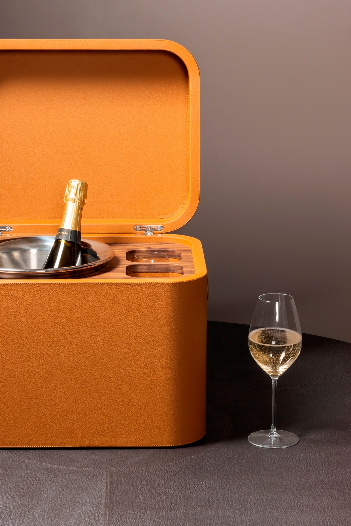 Giobagnara x Poltrona Frau champagne trunk | Luxurious leather-covered structure with hinged lid, walnut wood inlay, and elegant detailing | Includes two master glasses and a champagne bucket with insulated double-chamber polished steel insert | Entirely made in Pelle Frau® | Barware & trunks | 2Jour Concierge, your luxury lifestyle shop
