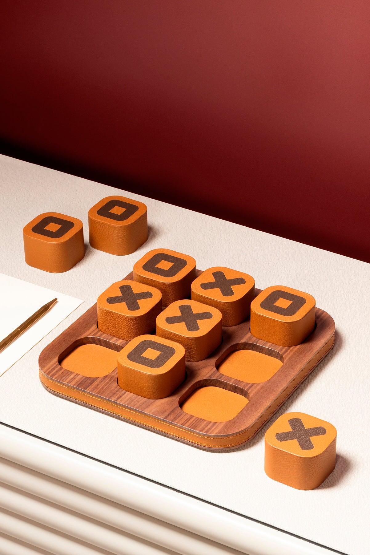 Giobagnara x Poltrona Frau tic tac toe | Leather-covered playing pieces with inlaid graphic motifs | Walnut wood base adorned with refined leather detailing | A luxurious twist on a classic game | Entirely made in Pelle Frau® | Home decor & game sets | 2Jour Concierge, your luxury lifestyle shop