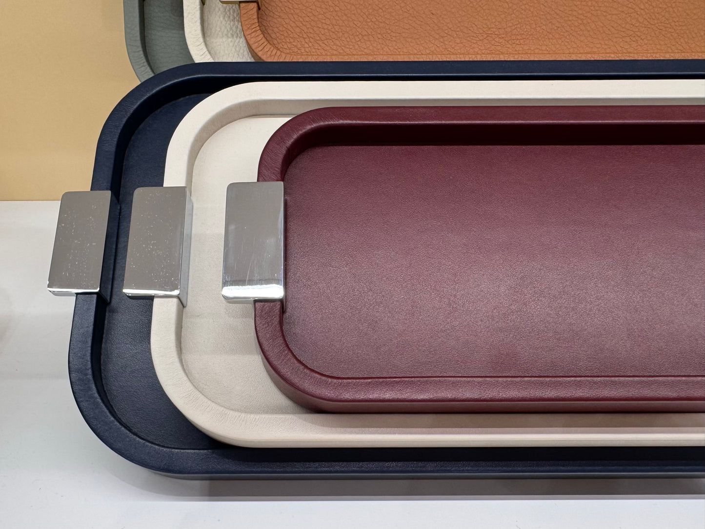 Giobagnara | Puccini Long Rectangular Tray: Leather-covered wood tray with metal handles in chrome, bronze, or brass | Serveware | 2Jour Concierge, your luxury lifestyle shop | luxury serving tray, Giobagnara Puccini, leather tray with handles, Italian designer tray, long rectangular tray