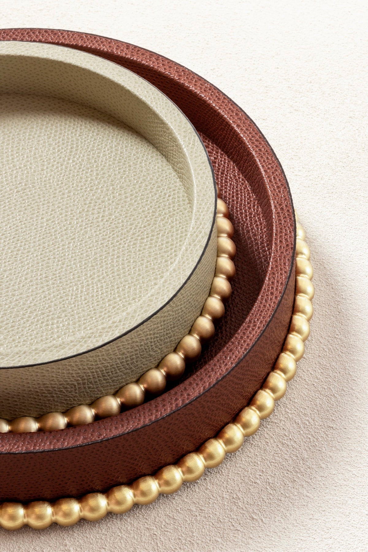 Giobagnara | Perla Round Valet Tray: Leather-covered round form with metal ring of linked spheres in chrome, bronze, or brass | Decor | 2Jour Concierge, your luxury lifestyle shop | luxury valet tray, Giobagnara Perla, round leather tray, Italian luxury decor, designer catch-all tray