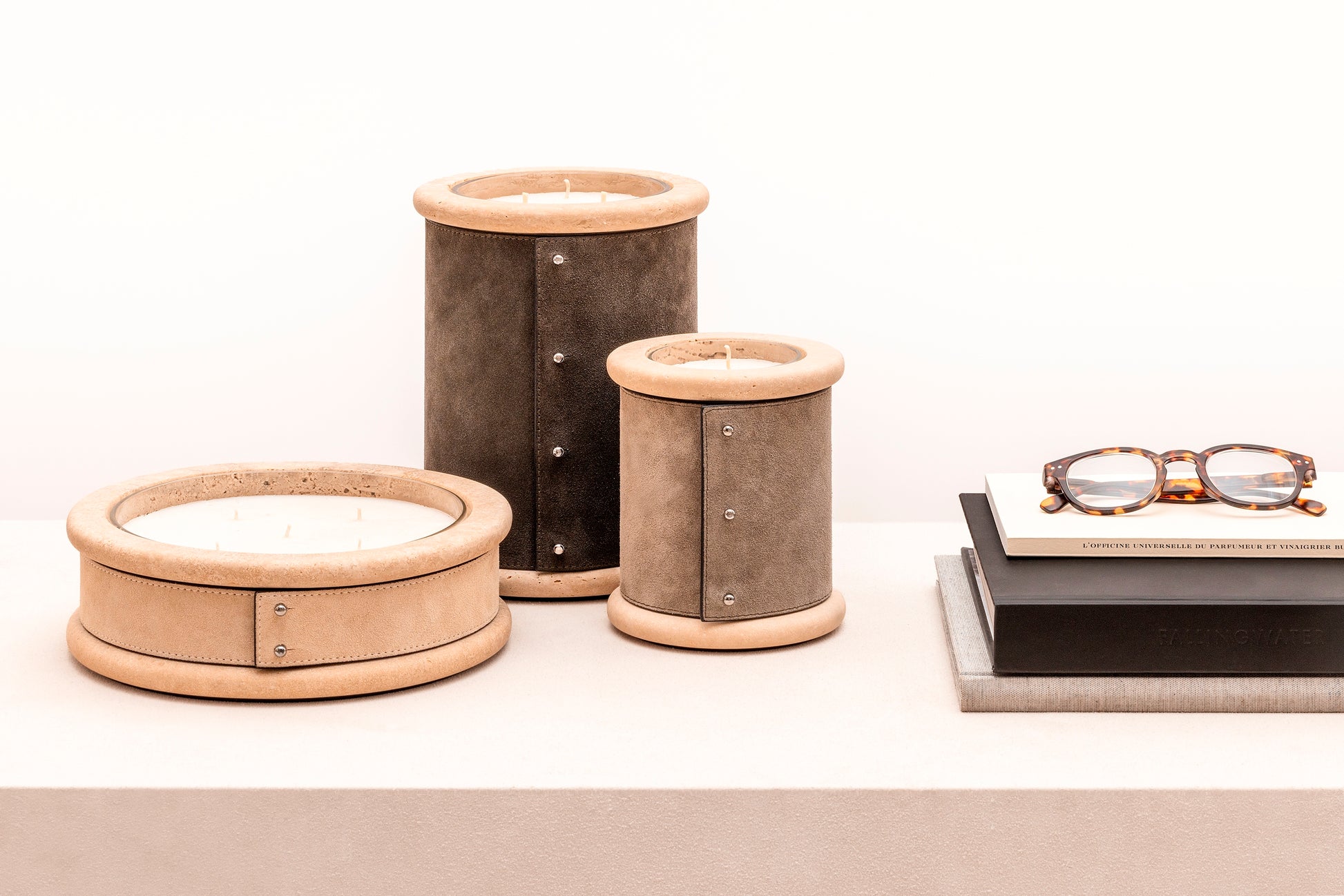 Giobagnara Ercolano leather & marble candle holder | Marble structure with removable wax candle and chrome-plated button details | Available in travertino marble | A refined blend of natural stone and luxury finishes | Home decor & candle holders | Versions: regular small (1 wick), low large (5 wicks), high large (3 wicks) | 2Jour Concierge, your luxury lifestyle shop