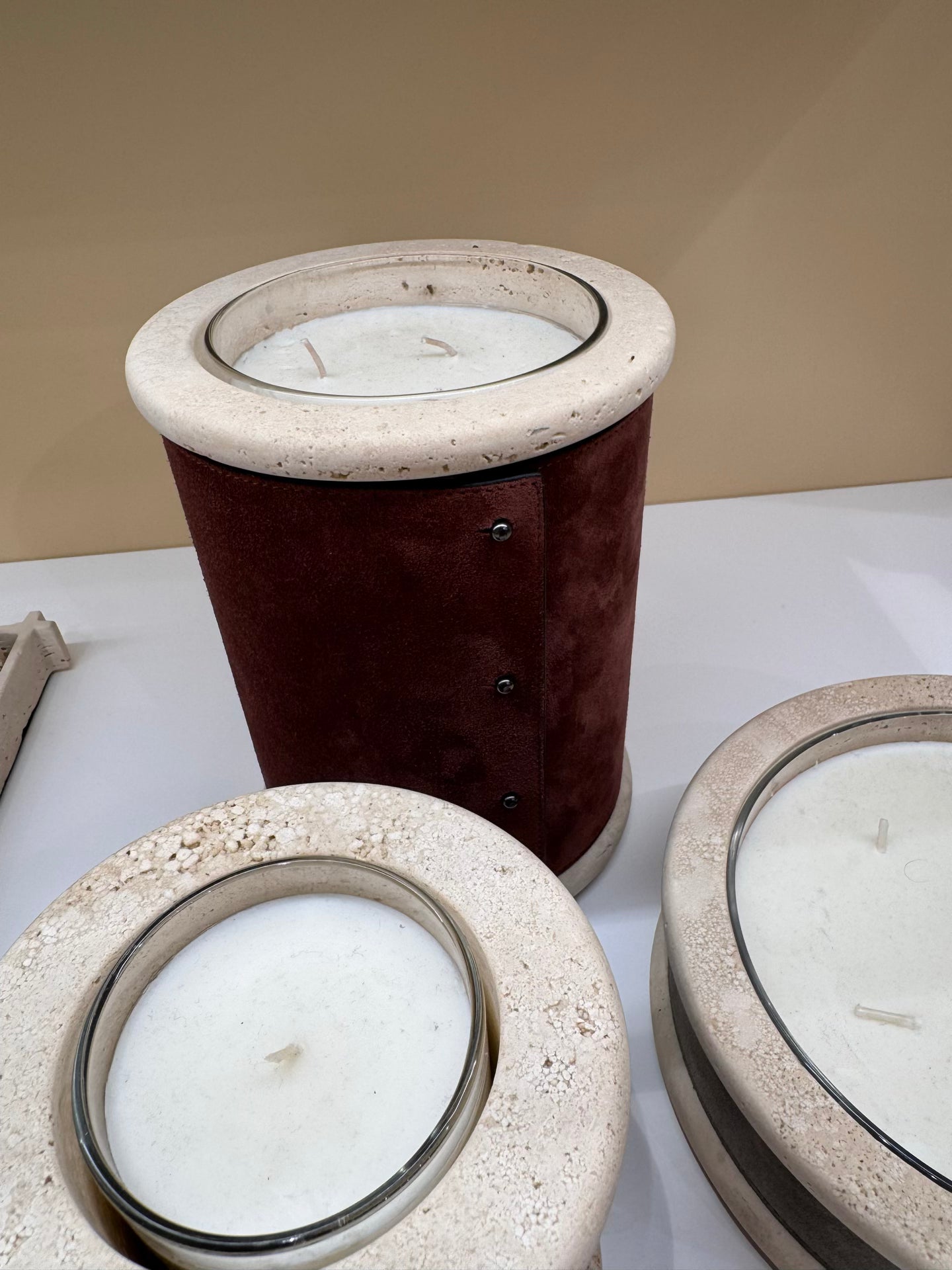 Giobagnara Ercolano leather & marble candle holder | Marble structure with removable wax candle and chrome-plated button details | Available in travertino marble | A refined blend of natural stone and luxury finishes | Home decor & candle holders | Versions: regular small (1 wick), low large (5 wicks), high large (3 wicks) | 2Jour Concierge, your luxury lifestyle shop