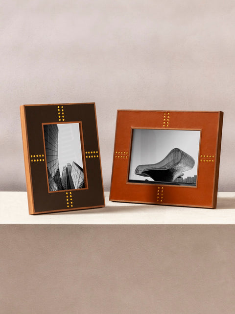 Rabitti 1969 | Toiles de Noyer Walnut Wood and Saddle Leather Picture Frame N°1: Walnut wood picture frame with saddle leather inserts and golden tacks, two sizes, magnetic back | Decor | 2Jour Concierge, your luxury lifestyle shop | luxury picture frame, Rabitti 1969, Toiles de Noyer, walnut leather frame, golden tack detail, Italian luxury decor, designer photo frame, Giobagnara leather frame