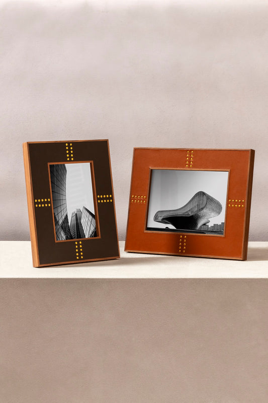 Rabitti 1969 | Toiles de Noyer Walnut Wood and Saddle Leather Picture Frame N°1: Walnut wood picture frame with saddle leather inserts and golden tacks, two sizes, magnetic back | Decor | 2Jour Concierge, your luxury lifestyle shop | luxury picture frame, Rabitti 1969, Toiles de Noyer, walnut leather frame, golden tack detail, Italian luxury decor, designer photo frame, Giobagnara leather frame