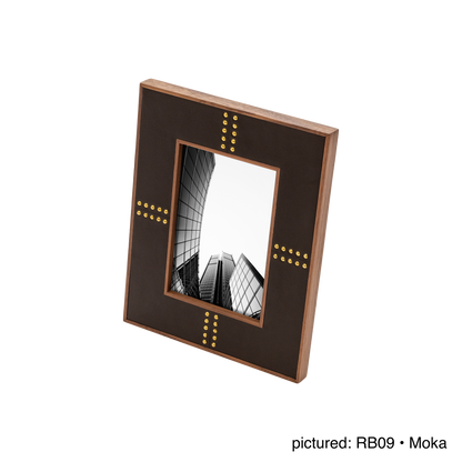 Rabitti 1969 | Toiles de Noyer Walnut Wood and Saddle Leather Picture Frame N°1: Walnut wood picture frame with saddle leather inserts and golden tacks, two sizes, magnetic back | Decor | 2Jour Concierge, your luxury lifestyle shop | luxury picture frame, Rabitti 1969, Toiles de Noyer, walnut leather frame, golden tack detail, Italian luxury decor, designer photo frame, Giobagnara leather frame