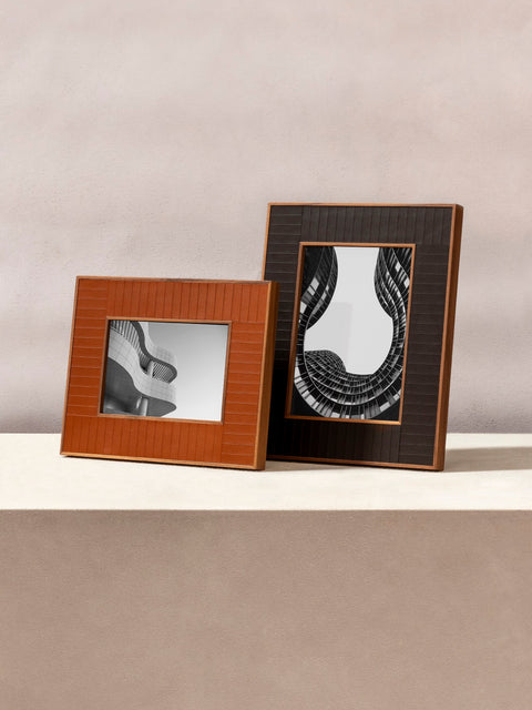 Rabitti 1969 | Toiles de Noyer Walnut Wood and Saddle Leather Picture Frame N°2: Walnut wood picture frame with saddle leather inserts engraved with vertical and horizontal stripes, two sizes, magnetic back | Decor | 2Jour Concierge, your luxury lifestyle shop | luxury picture frame, Rabitti 1969, Toiles de Noyer, walnut leather frame, engraved leather detail, Italian luxury decor, designer photo frame, Giobagnara leather frame