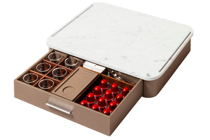 Giobagnara Saint-Germain deluxe coffee and tea drawer organizer + cups | Luxurious organizer for Nespresso classic capsules and tea service | Leather-covered wood structure with metal inserts in three finishes | Top customizable in leather, Corian®, or marble (classic travertine or arabescato white) | Inner walnut wood partitions hold coffee spoons, sugar, 24 capsules, 6 double-wall borosilicate glass cups, and 6 nesting rectangular saucers (all included) | Option to replace glass cups with sieger porcelain