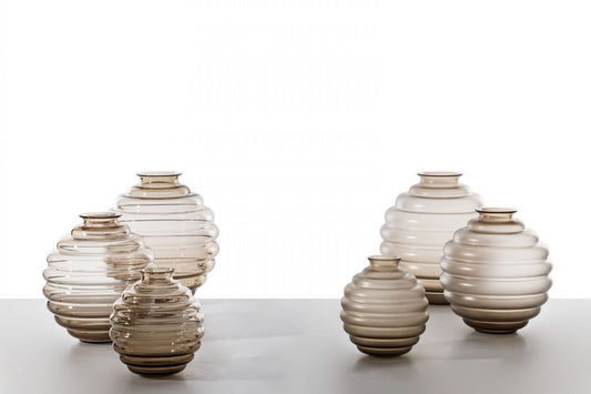 Venini Deco Vase | A Murano glass vase defined by rhythmic, flowing rings that expand and contract in a graceful, dance-like motion | Originally designed by Napoleone Martinuzzi in 1930, the Deco vase embodies timeless elegance and sculptural harmony | The repeated circular forms create a play of ripples and reflections, capturing the essence of movement | A celebrated icon of Venetian glass artistry | Design by Venini | Tableware & decorative objects | 2Jour Concierge, your luxury lifestyle shop.

